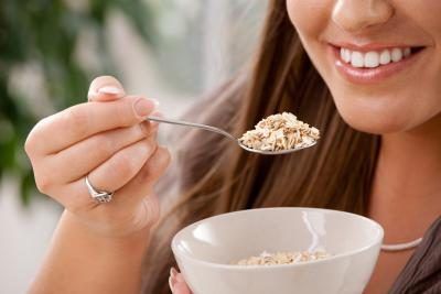 Gros plan d'une jeune femme de manger des céréales à grains sains