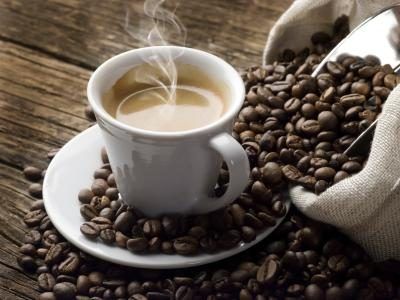 Tasse de café et les grains de café chaud sur une table
