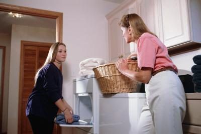 Mère faire le lavage tout en déléguant des tâches à sa fille