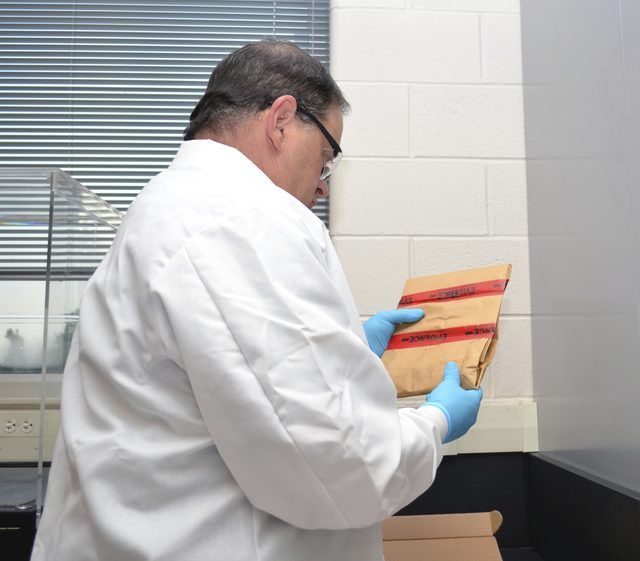 A Forensics scientifique détient une évidence de l'enveloppe contenant une scène de crime.