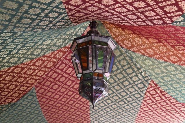 Une lampe marocaine suspendue au centre d'un auvent.