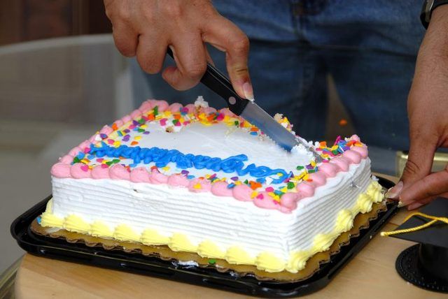 Un homme découpe un gâteau.