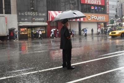 Un portier en essayant de héler un taxi sous la pluie