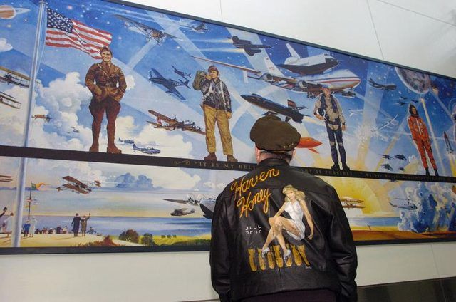 Man admire murale géante sur la naissance de vol