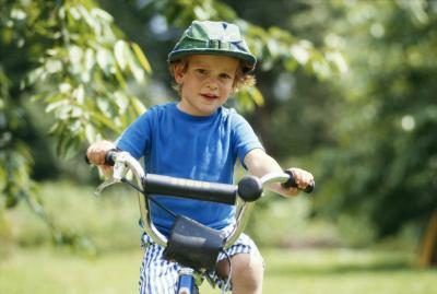 Un garçon porte un casque en vélo extérieur.