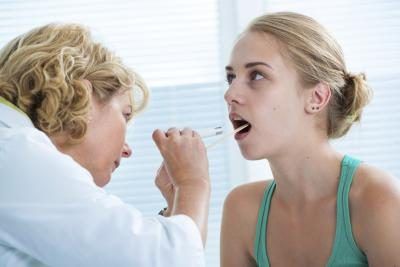 Docteur regardant dans la bouche des patients