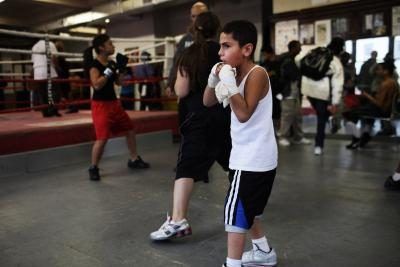 Boy boxe pratiquer dans le gymnase de la communauté