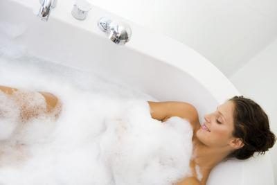 femme détend les muscles dans un bain chaud