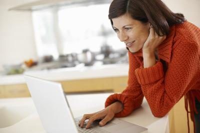 Une femme utilise son ordinateur dans le kithcen.