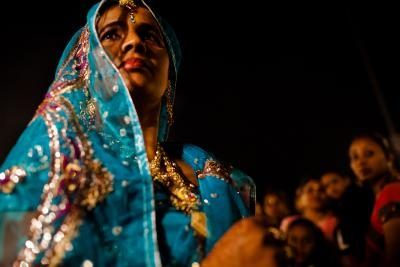 La femme en bleu Sari regarder la procession de mariage