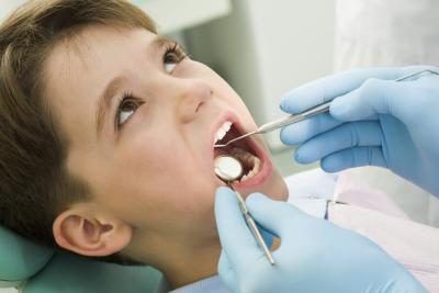 dentiste regardant dans garçon's mouth