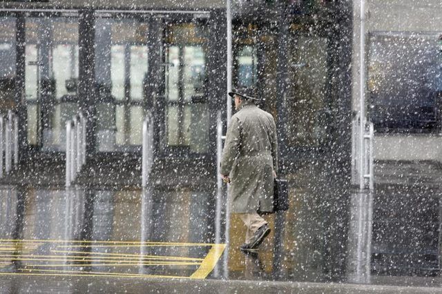 Un homme marchant dans la neige pour se rendre à un immeuble de bureaux