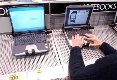 Man teste Compaq ordinateur portable à côté d'un ordinateur portable Hewlett Packard