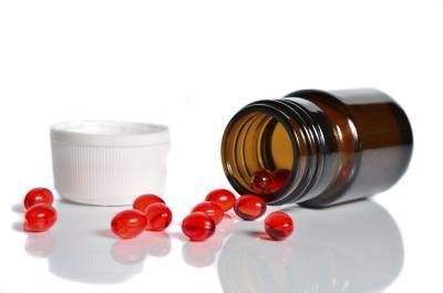 Jar renverser pilules rouges sur une table.
