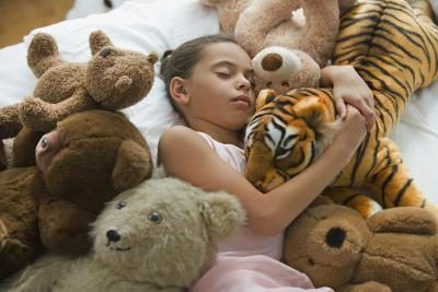 enfant endormi avec des animaux en peluche