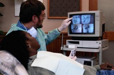 Dentiste expliquant images diagnostiques.
