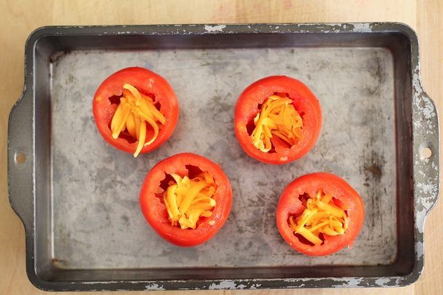 Ajouter le fromage râpé au fond des tomates évidées.