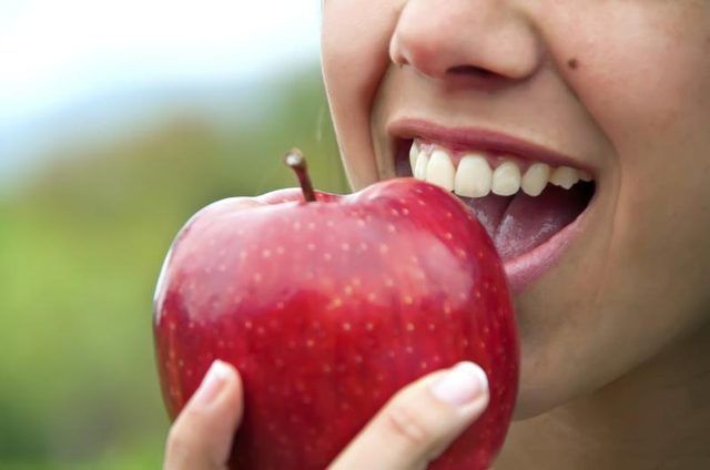 Close-up d'une femme de prendre une bouchée d'une pomme