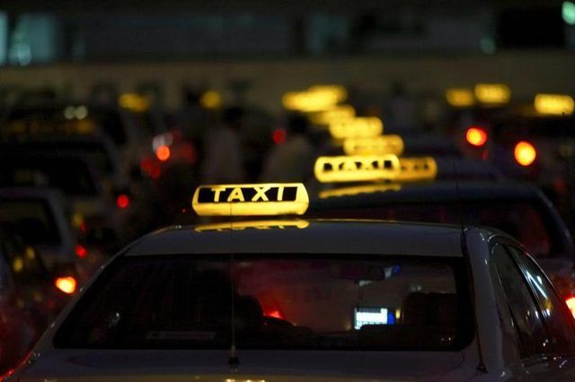 Une rangée de taxis dans la nuit.