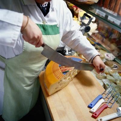 Deli travailleur trancher fromage suisse