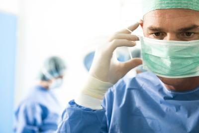 Un chirurgien enlève la partie supérieure de l'utérus dans une hystérectomie partielle.