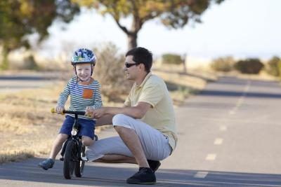 Boy avec le père apprendre à monter à bicyclette