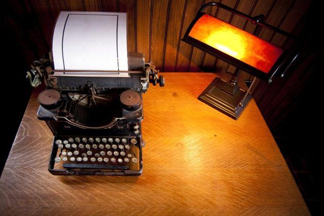 Bureau avec vieille machine à écrire et une lampe.
