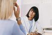 Une femme parle avec son médecin au sujet des symptômes persistants.