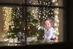Jeune fille de mettre la table pour le dîner devant un arbre de Noël.