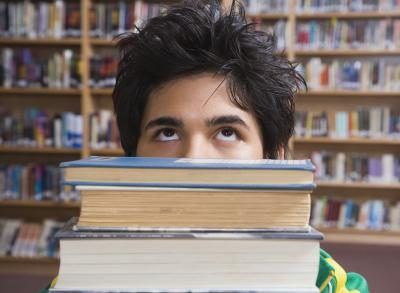 Un adolescent avec pile de livres