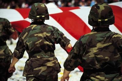 Soldats américains marchant à côté d'un drapeau américain.