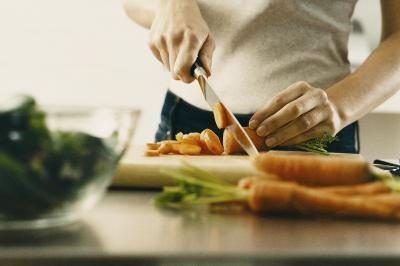Femme couper les légumes dans la cuisine