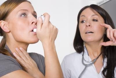 Femme utilisant un inhalateur pour l'asthme en délibéré du médecin du travail.