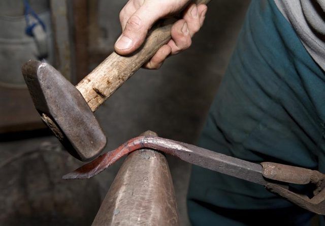 Utilisation de marteau pour plier objet de métal chaud