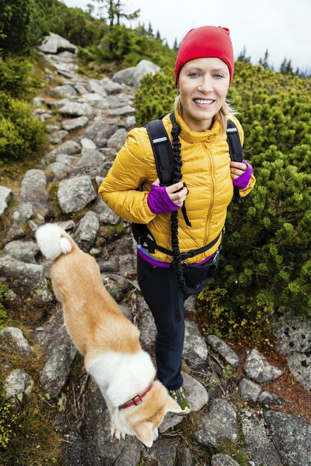 Une femme va pour une randonnée côtière avec son chien.