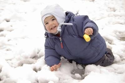 Un bambin joue dans la neige.